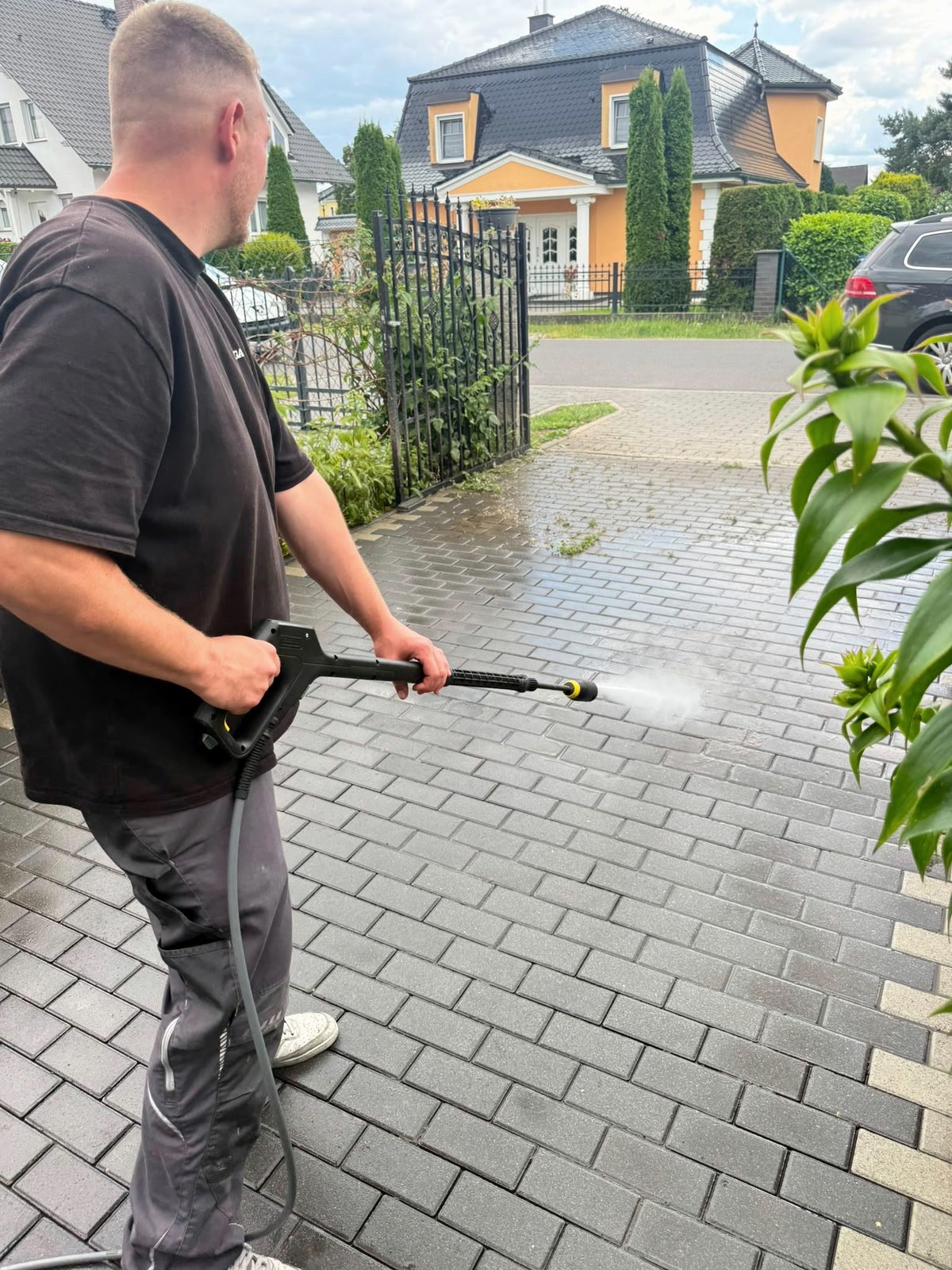 Flächenreinigung mit der Hochdruckpistole auf Pflaster, JaWi-Arbeitskleidung